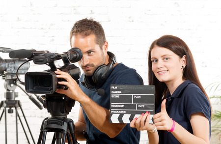 a cameraman and a young woman with a movie cameraの写真素材