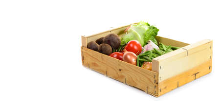 wooden crate with seasonal vegetables on white background