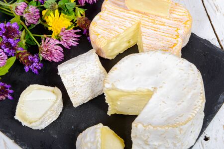 french cheeses on a black slate and flowersの写真素材