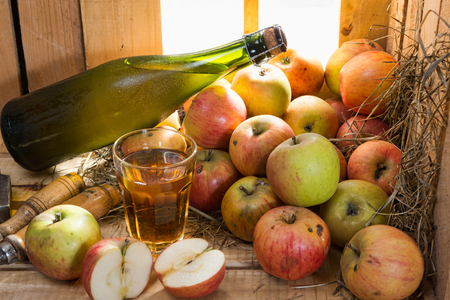 bottle and glass of cider with applesの写真素材