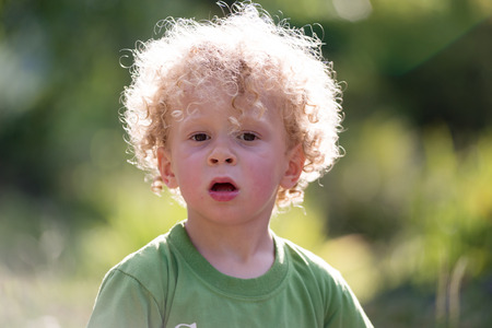 a portrait of a little blond curly boyの写真素材