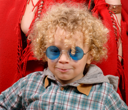 a portrait of a little blond curly boy whit blue eyeglassesの写真素材