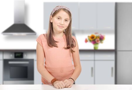 a smiling young girl in a kitchenの写真素材