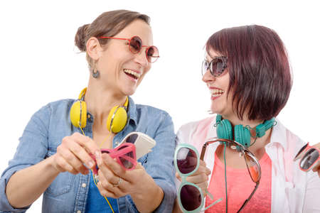 two pretty women trying on sunglasses, isolated on white