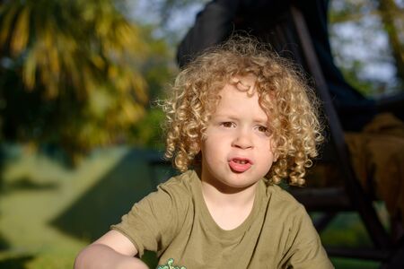 a portrait of a young boy with blond curly hairの写真素材