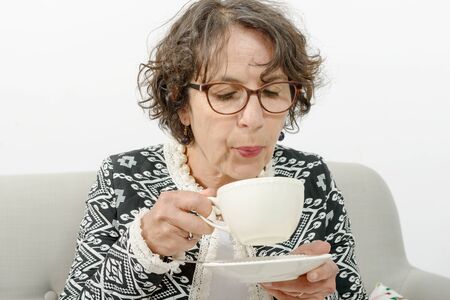 a beautiful mature woman drinking teaの写真素材