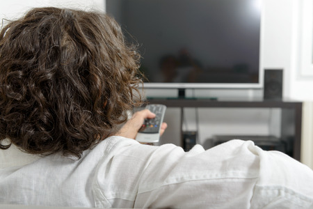 A middle-aged woman with a tv remote controlの写真素材