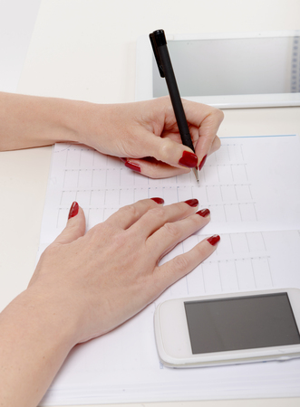 a closeup of woman's hand writing on paperの写真素材