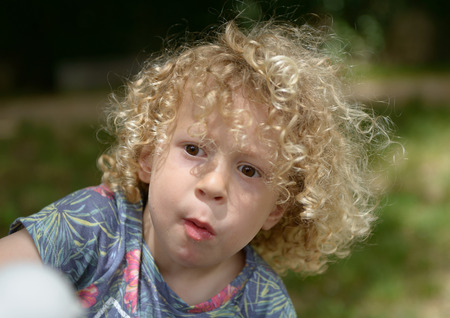 a portrait of a little boy with curly hairの写真素材