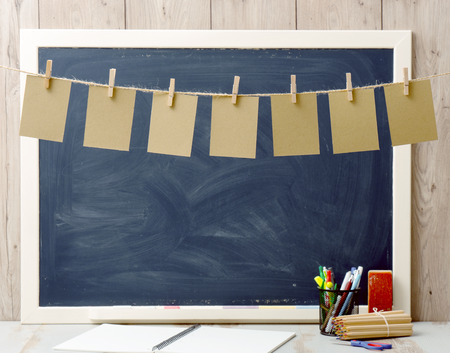 seven sheets of paper hanging and blackboard in background