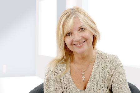 Portrait of blond mature woman relaxing in sofa