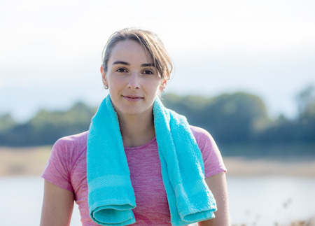 portrait of young sporty woman with blue towel in the countrysideの写真素材