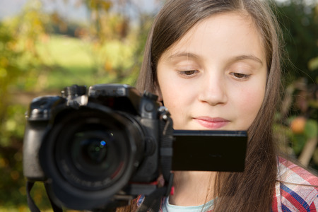 beautiful teenage girl with a camera, outdoorsの写真素材