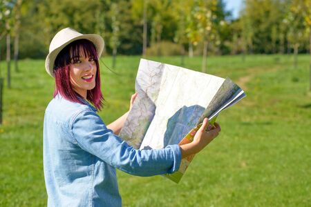 beautiful young woman with hat and map in the countrysideの写真素材