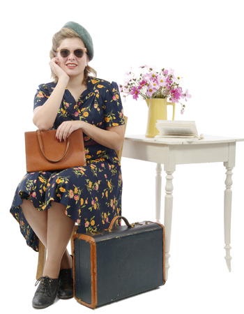 beautiful young  woman with vintage clothes sitting on chairの写真素材