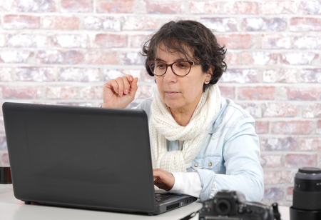 Portrait of brunette mature woman using laptopの写真素材