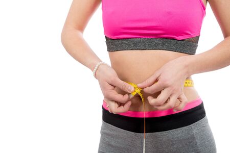 woman measuring her waist with a measure tape isolated on  white backgroundの写真素材