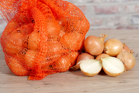 lot of fresh onions on a wooden tableの写真素材