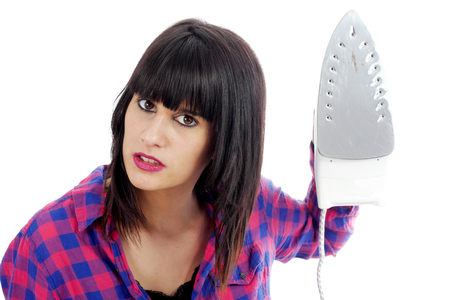 a young angry woman holding an ironの写真素材