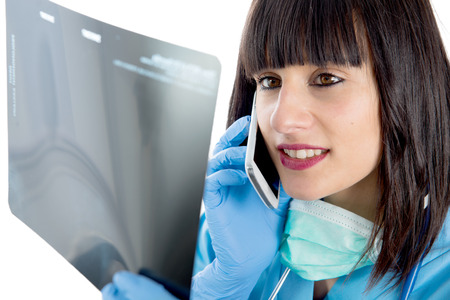 a young female doctor with stethoscope looking at patients x-ray