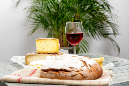 Different french cheeses with a glass of red wineの写真素材