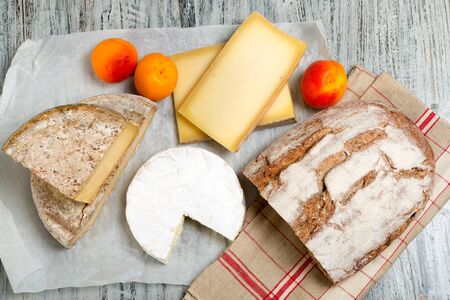 Different french cheeses with a bread and apricotsの写真素材