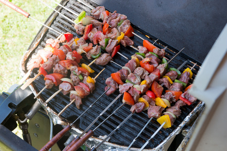 Skewers of meat and vegetables on the barbecueの写真素材