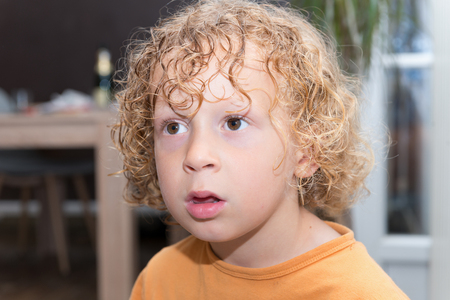 Portrait of a little boy with blond and curly hairの写真素材