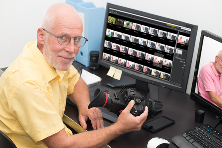 manphotographer with camera at office with computer