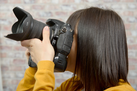 Attractive brunette woman with photo camera