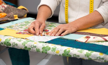 Close up of woman's hand sewing patchwork