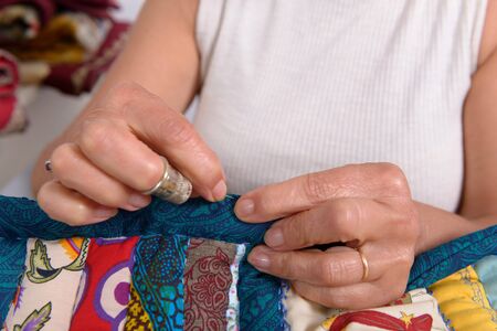 seamstress woman sewing for finish a quilt.の写真素材