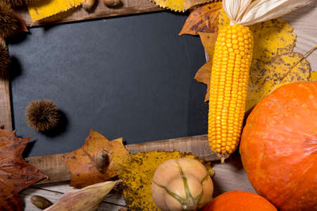a blackboard with Autumn decorations on wood. top view,の写真素材