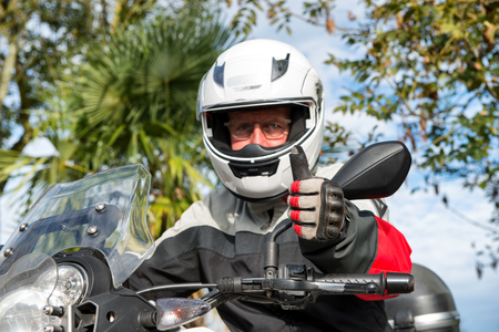 a portrait of a senior biker on his motorcycleの写真素材