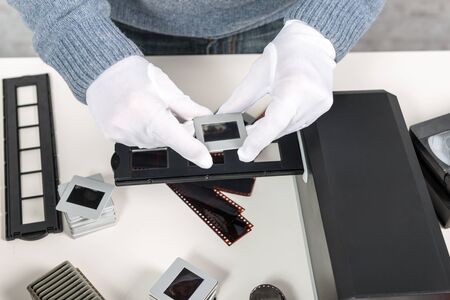 a man photographer looking at film slideの写真素材