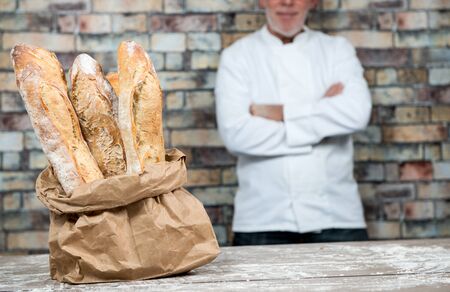 baker with traditional bread french baguettesの写真素材