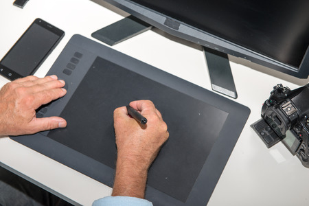 a man working on his graphics tablet, close up of hands