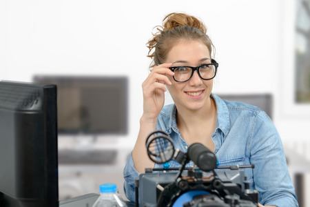 Smiling young woman video editing in office