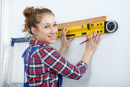 a young smiling woman using spirit level