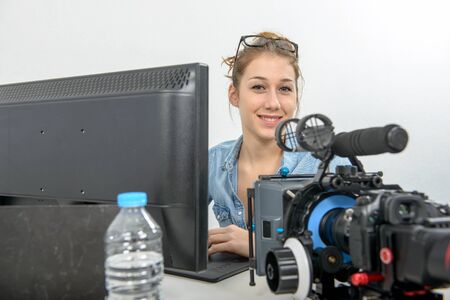a pretty young woman photographer with camera in office