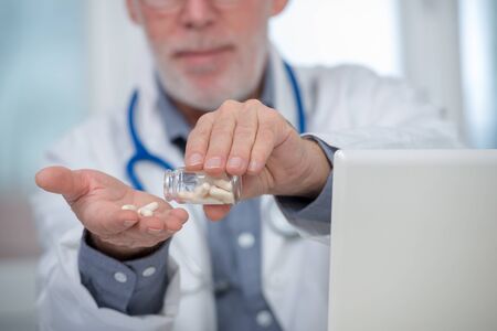 mature doctor with pill in the hospitalの写真素材