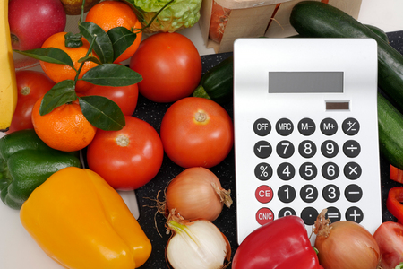 vegetables with a calculator on the white tableの写真素材