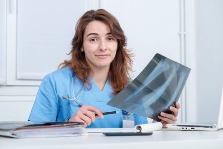 smiling medical woman doctor looking at scan image