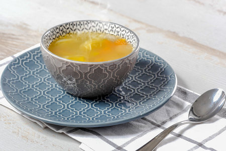a bowl of soup of vegetables on blue towelの写真素材