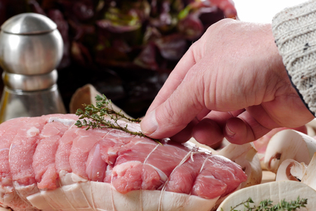 preparation of uncooked roast pork with mushroomsの写真素材