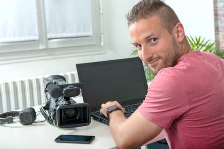 a video editor with computer and professionnal video cameraの写真素材