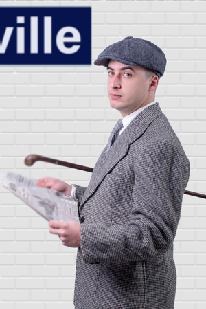 young man in vintage clothes with hat, reading a newspaper, 1940 styleの写真素材