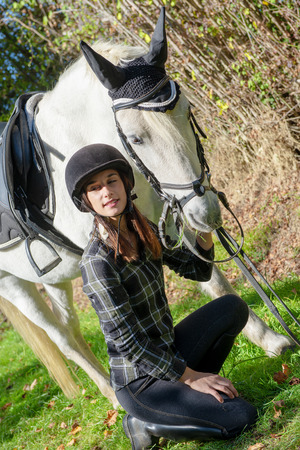 a young rider woman with white horseの写真素材