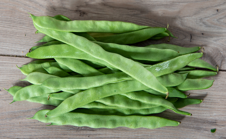 Fresh flat green beans on a wooden tableの写真素材