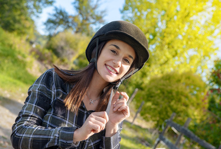 Portrait of a happy female jockey with an  helmet